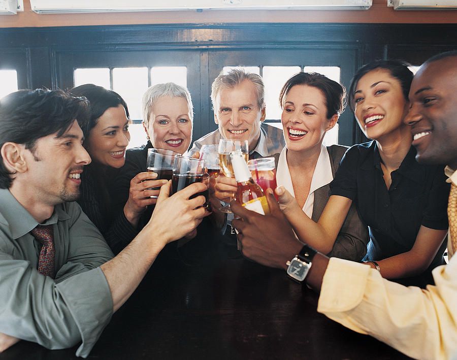 Businessmen and Businesswomen Work Colleagues Toasting in a Bar Photograph by Digital Vision.