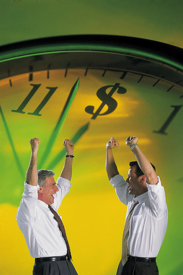 Businessmen cheering with clock Photograph by Comstock