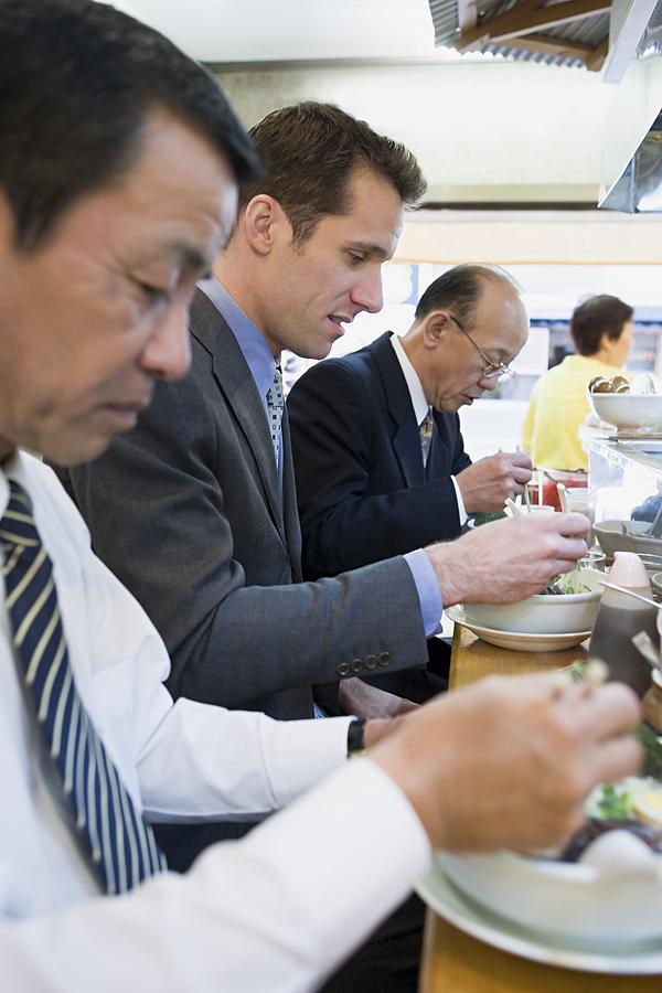 Businessmen eating Photograph by Image Source