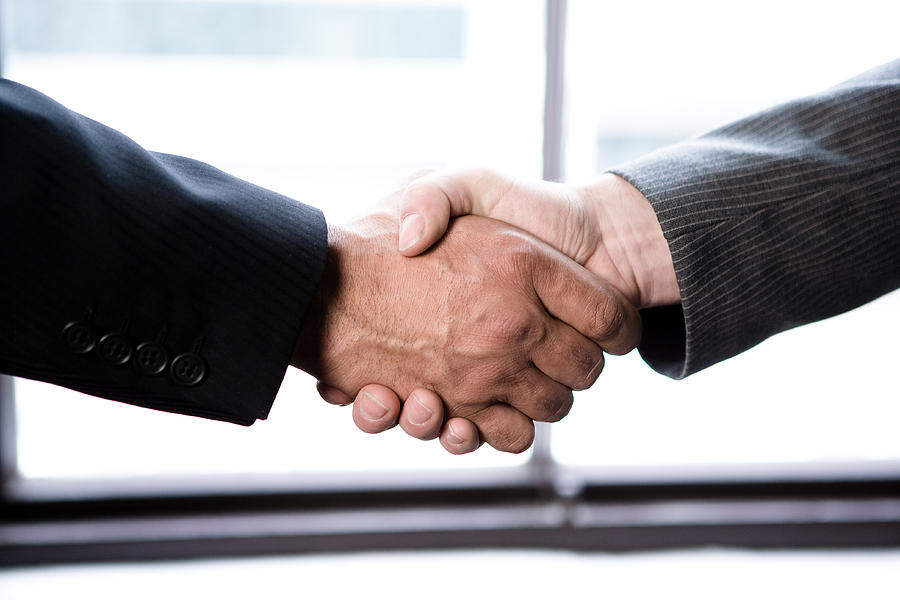 Businessmen handshake Photograph by Jupiterimages