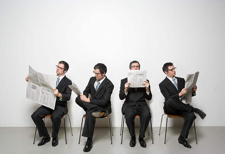 Businessmen reading newspaper Photograph by Image Source