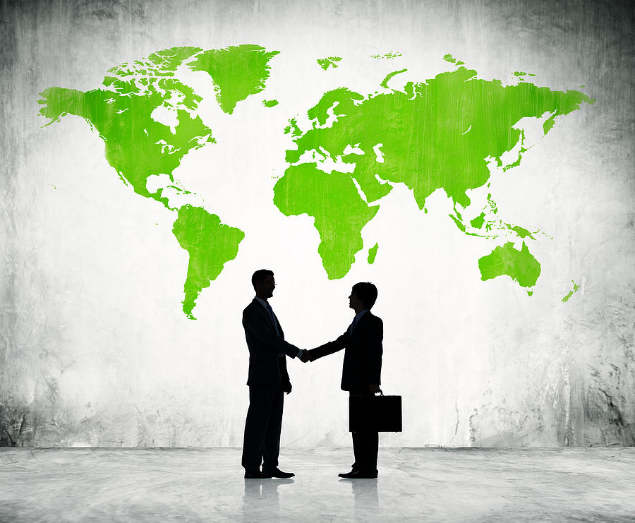 Businessmen shake hands with green land background Photograph by Rawpixel