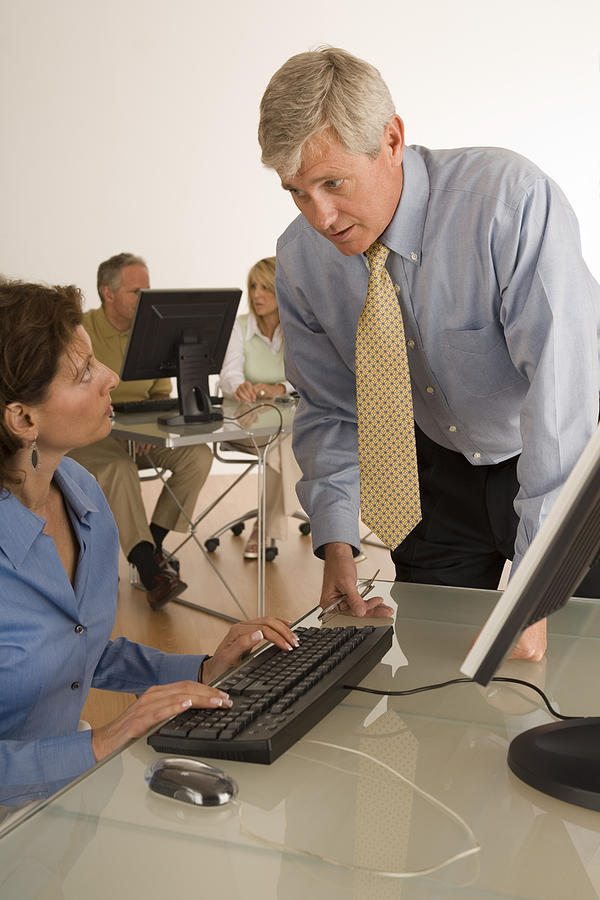 Businesspeople conversing by computer Photograph by Comstock Images