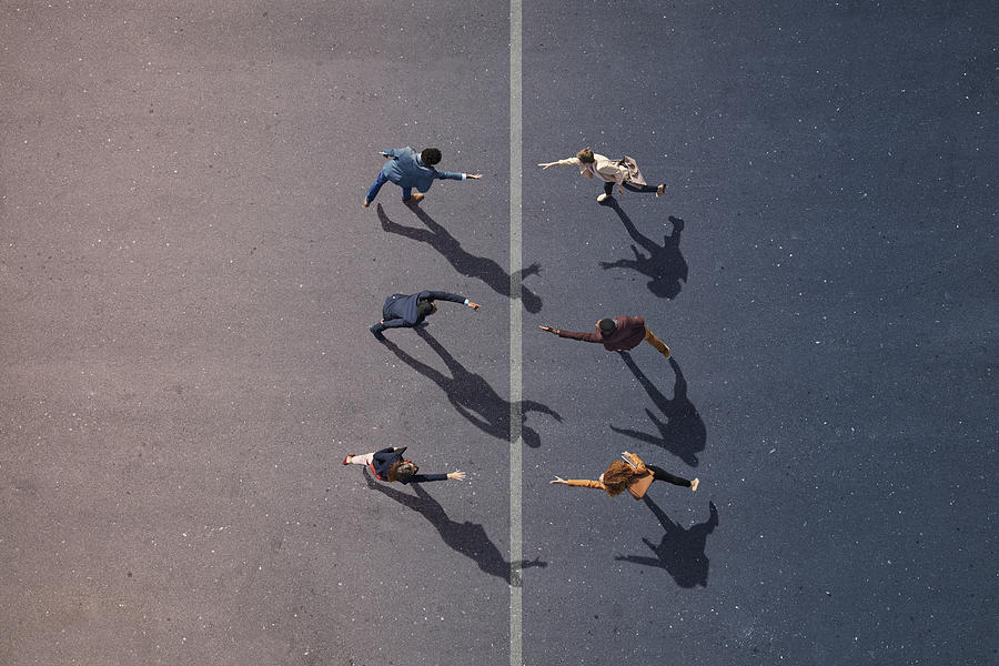 Businesspeople stretching towards each other, on painted asphalt Photograph by Klaus Vedfelt