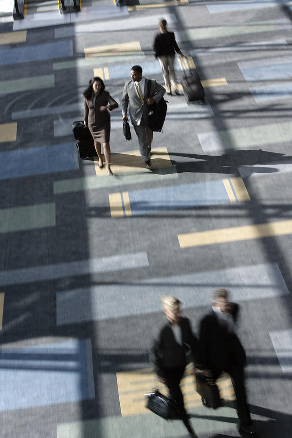 Businesspeople walking in airport Photograph by Comstock Images