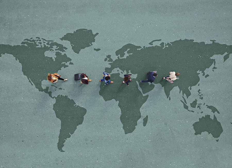 Businesspeople walking in line across world map, painted on asphalt Photograph by Klaus Vedfelt