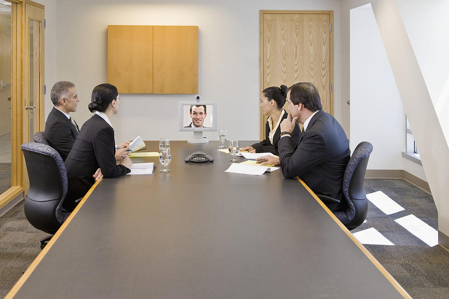Businesspeople watching video conference in a conference room Photograph by Andersen Ross