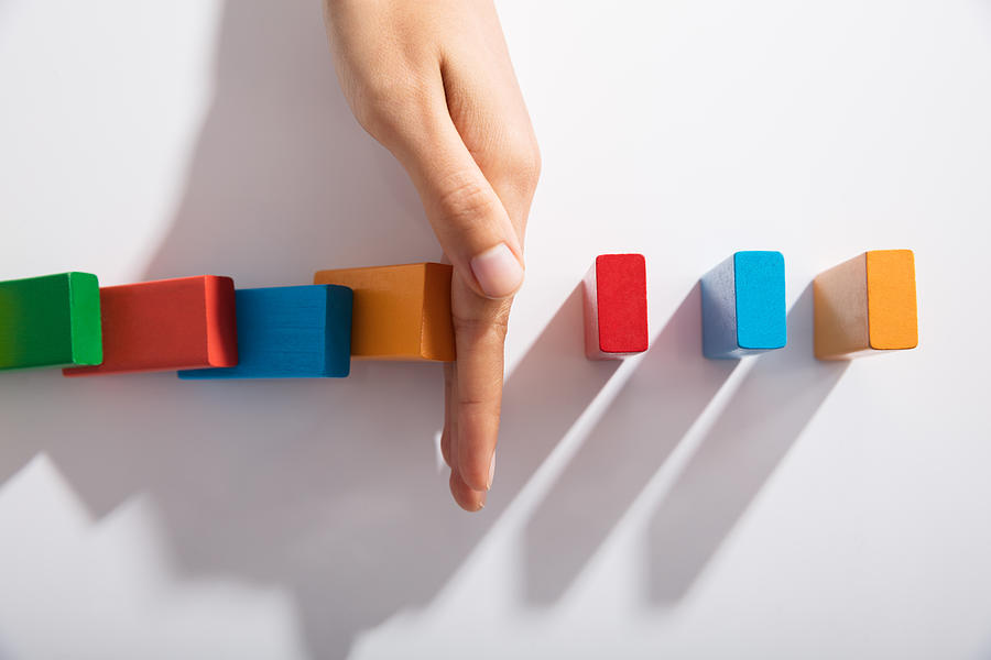 Businessperson Hand Stopping Colorful Blocks From Falling Photograph by AndreyPopov