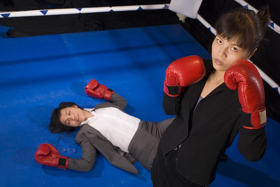 Businesswoman after knocking down her opponent in a boxing ring Photograph by Asiaselects