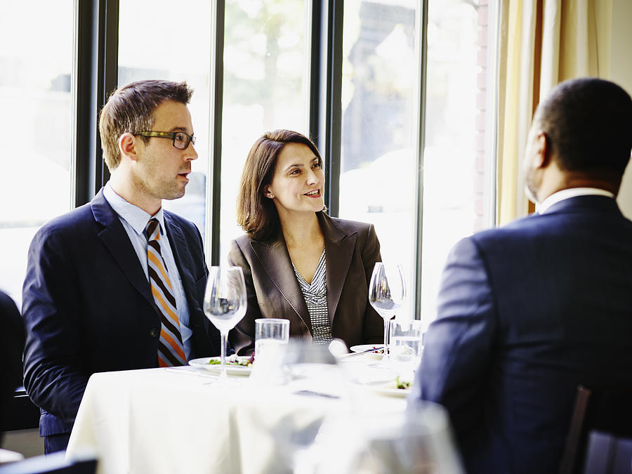 Businesswoman and businessman at lunch meeting Photograph by Thomas Barwick