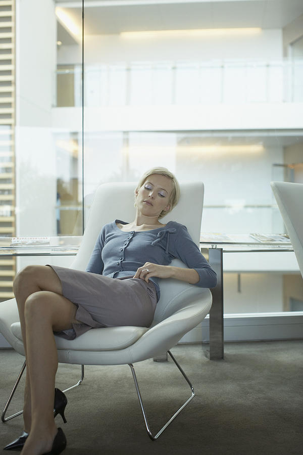 Businesswoman asleep in chair Photograph by Justin Pumfrey