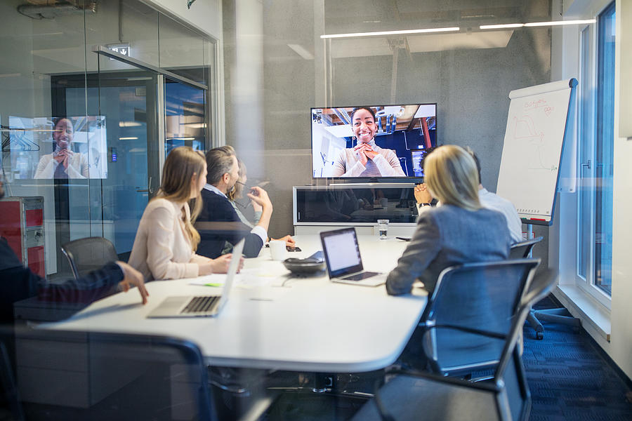 Businesswoman having video conference meeting with team Photograph by Luis Alvarez