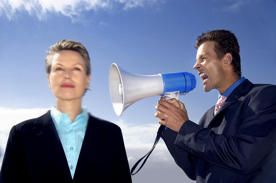 Businesswoman Ignoring a Businessman Shouting at Her Through a Megaphone Photograph by John Cumming