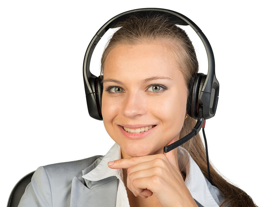 Businesswoman in headset sitting on chair, hand under chin Photograph by Cherezoff
