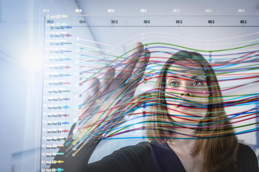 Businesswoman inspecting graph on interactive display Photograph by Monty Rakusen