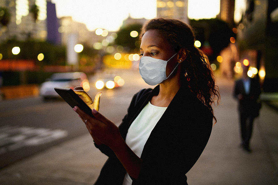 Businesswoman outdoors wearing healthcare mask. Photograph by Stevecoleimages