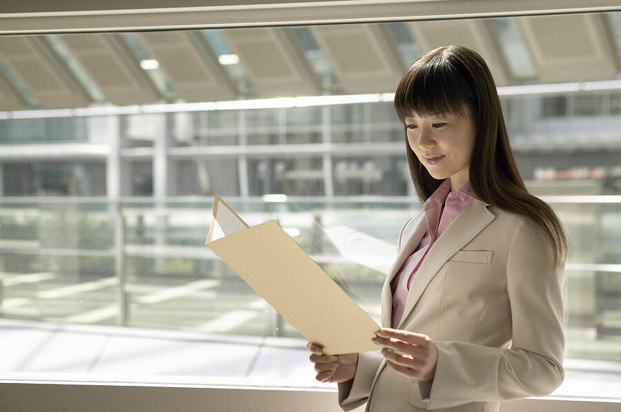 Businesswoman Reading a Document Photograph by Digital Vision.