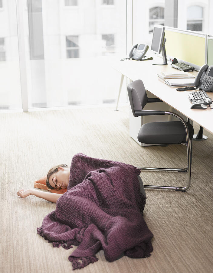 Businesswoman sleeping on office floor Photograph by Robert Daly