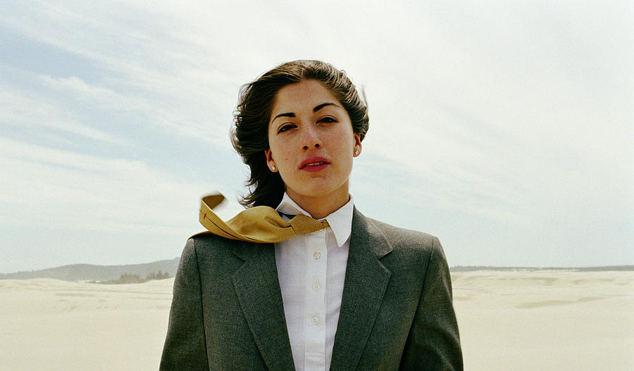 Businesswoman standing in desert, portrait Photograph by Matthias Clamer
