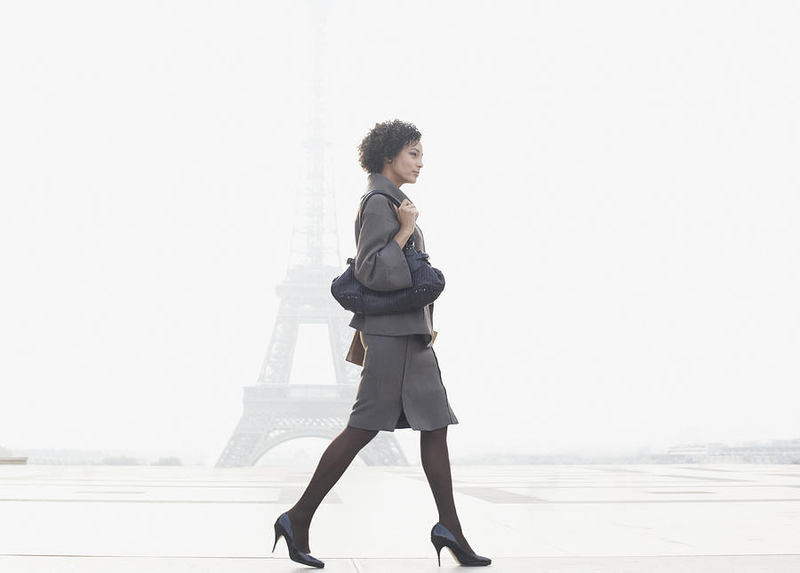 Businesswoman walking in plaza by Eiffel Tower Photograph by Sam Edwards
