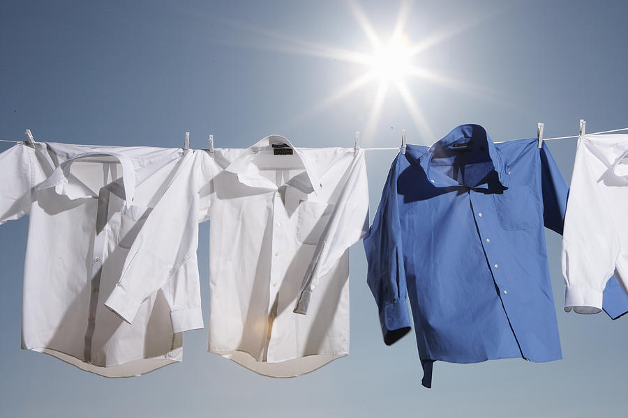 Button down shirts hanging from clothesline outdoors, low angle view Photograph by Thomas Northcut