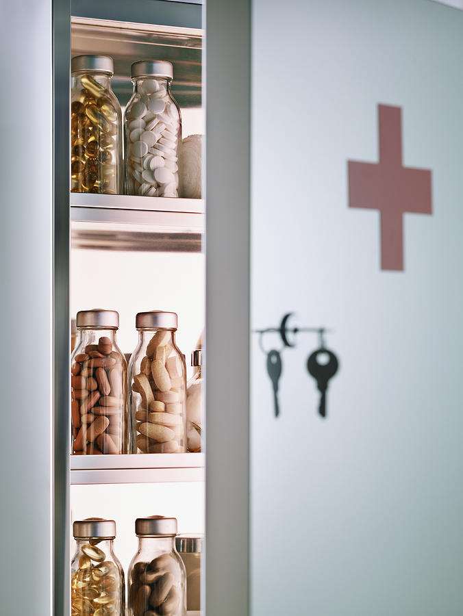 Cabinet with pill bottles next to hanging keys  Photograph by Chris Ryan