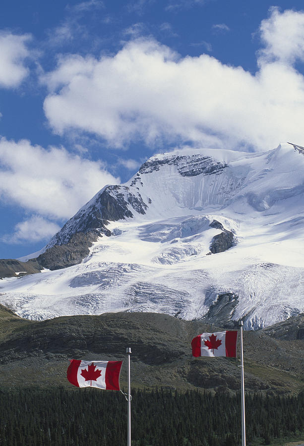 Canada, Banff National Park, Rocky Mountains, Canadian flags with mountains in background Photograph by Grant Faint