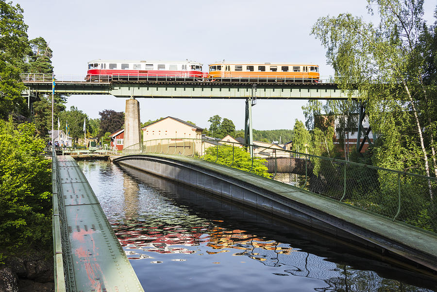 Canal, train on bridge Photograph by Johner Images