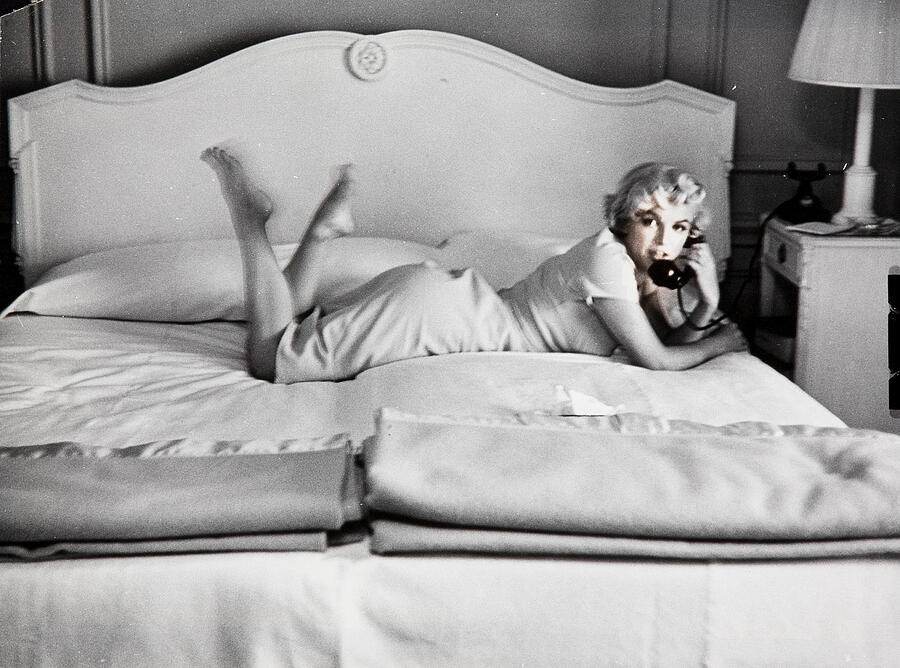 Marilyn Monroe Digital Art - Candid photographs depicting Marilyn laying barefoot across a bed while speaking on the phone, the o by Marilyn Monroe