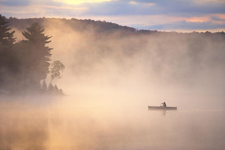 Canoe on a foggy lake Photograph by Comstock Images