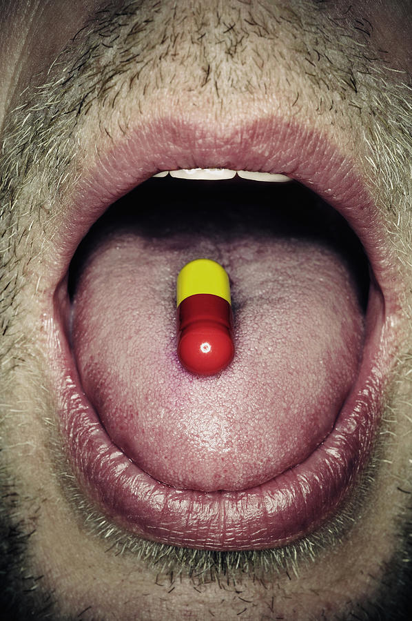Capsule on mans tongue, close-up Photograph by PhotoAlto/Neville Mountford-Hoare