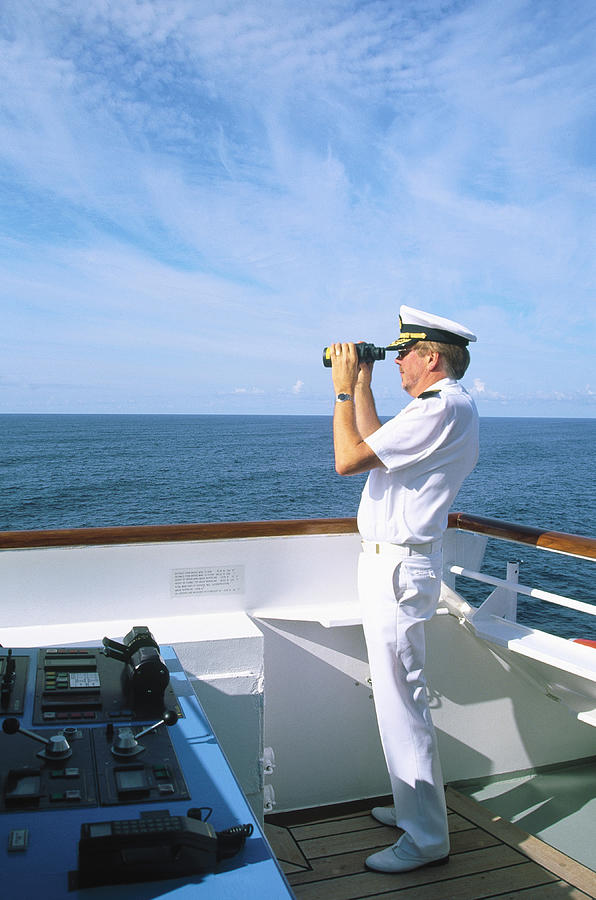 Captain w/ binoculars on bridge of cruise ship Photograph by Barry Winiker