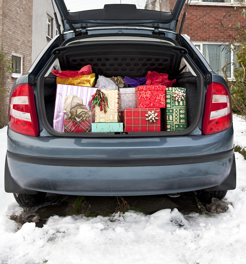 Car boot, filled with Christmas presents, snow underfoot Photograph by Liz Leyden