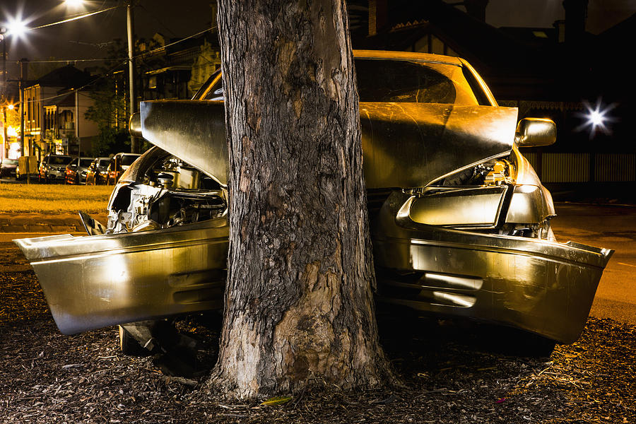 Car crashed on tree trunk at night Photograph by Tobias Titz