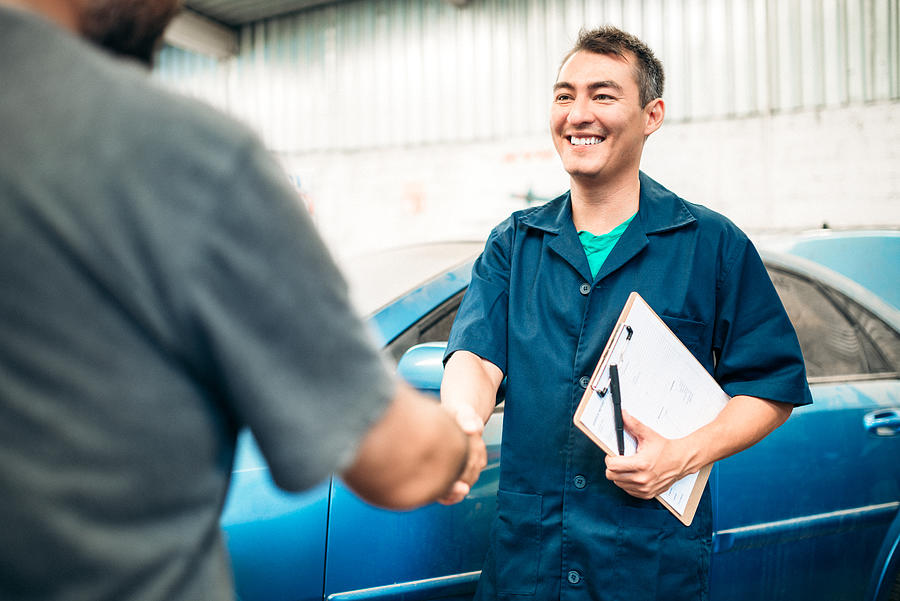 Car mechanic handshakes customer Photograph by Ferrantraite