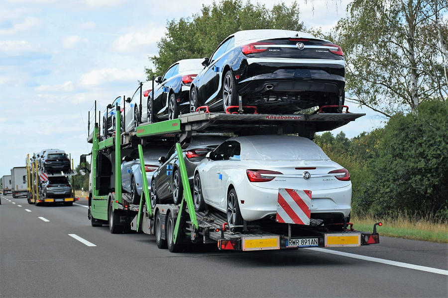 Car transporters driving on the highway Photograph by Tramino