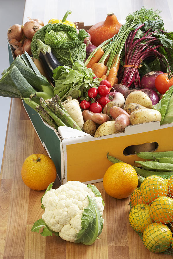 Cardboard box of assorted vegetables on kitchen counter Photograph by Martin Poole