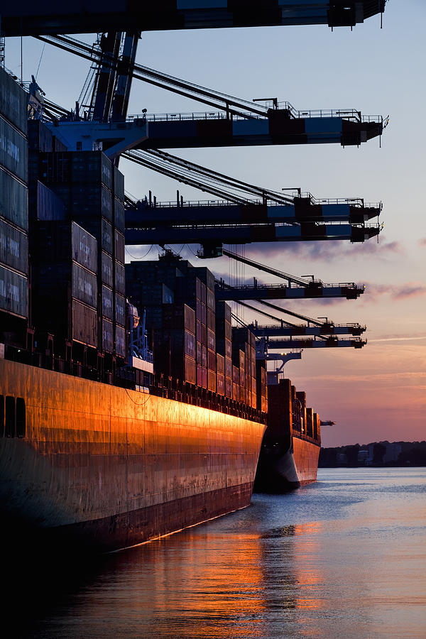 Cargo ships in container terminal sunset Photograph by Jorg Greuel