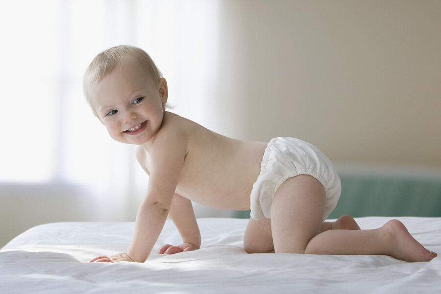 Caucasian baby girl crawling on bed Photograph by Jose Luis Pelaez Inc