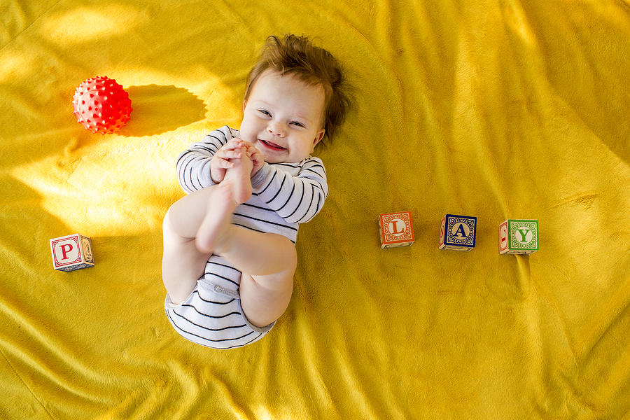 Caucasian baby girl playing with blocks on bed Photograph by Adam Hester
