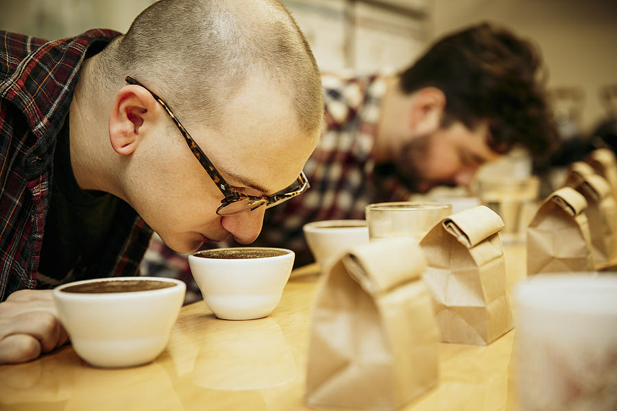 Caucasian baristas smelling coffee in cups Photograph by Inti St Clair