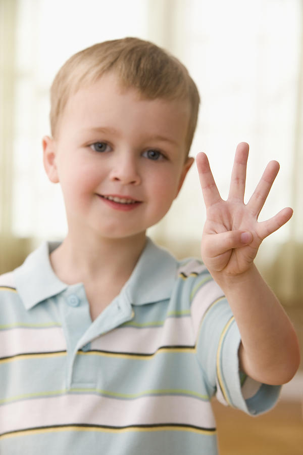 Caucasian boy holding up four fingers Photograph by Jose Luis Pelaez Inc