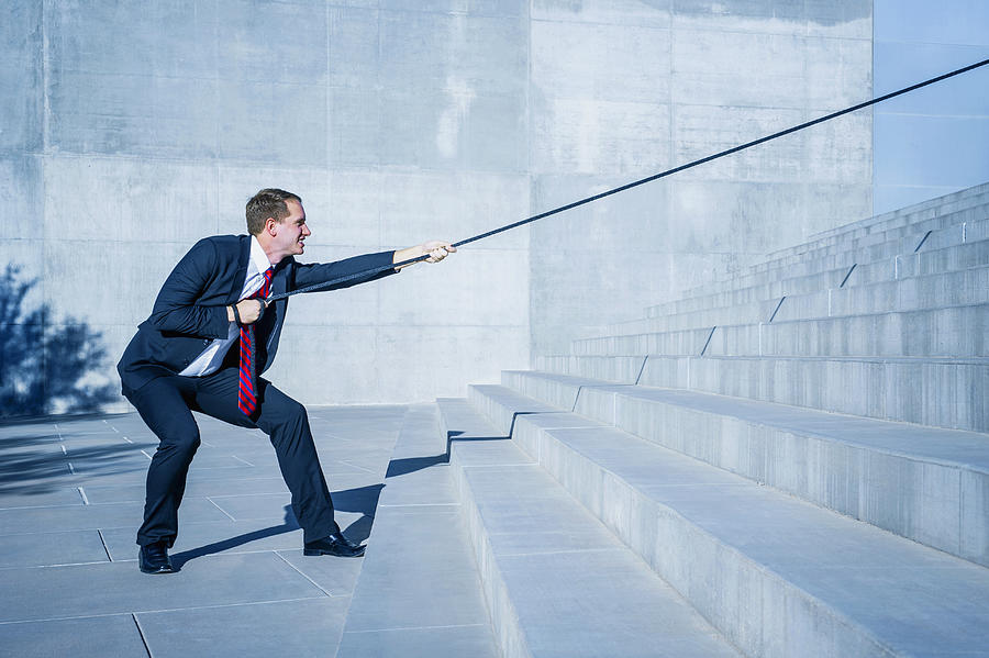 Caucasian businessman pulling rope down outdoor staircase Photograph by Jacobs Stock Photography Ltd