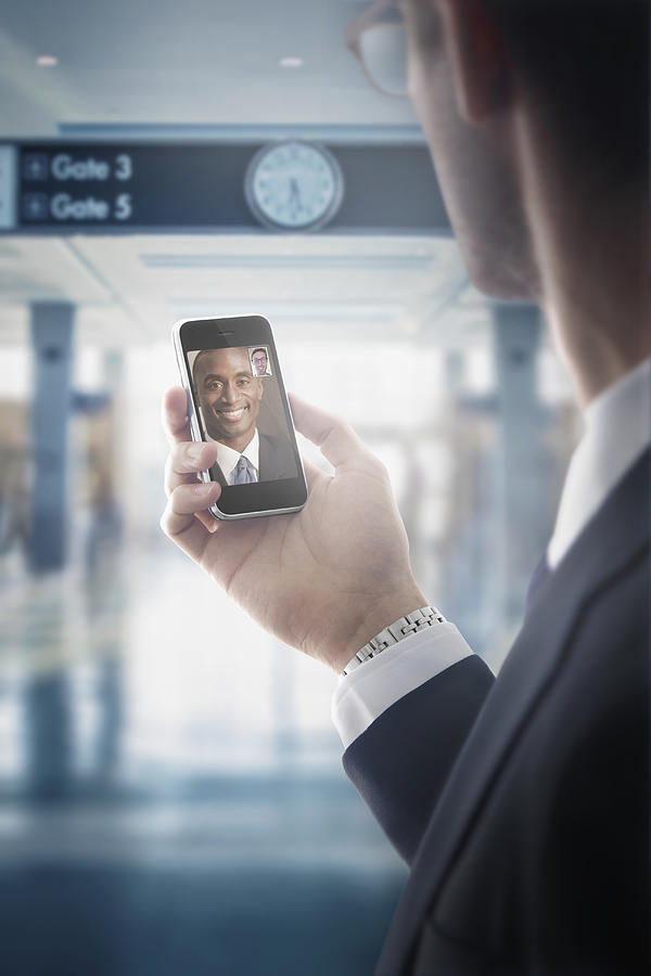 Caucasian businessman text messaging on cell phone in airport Photograph by John Fedele