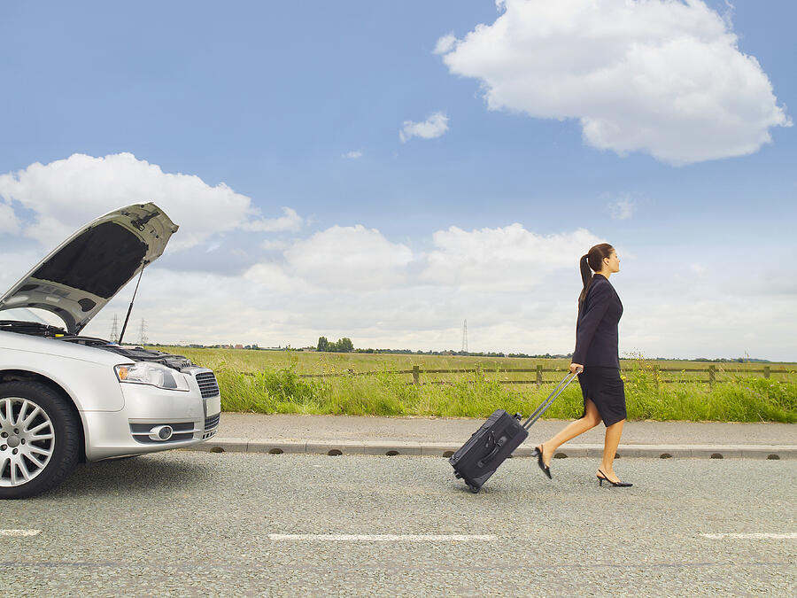 Caucasian businesswoman leaving broken down car on rural road Photograph by Jacobs Stock Photography Ltd