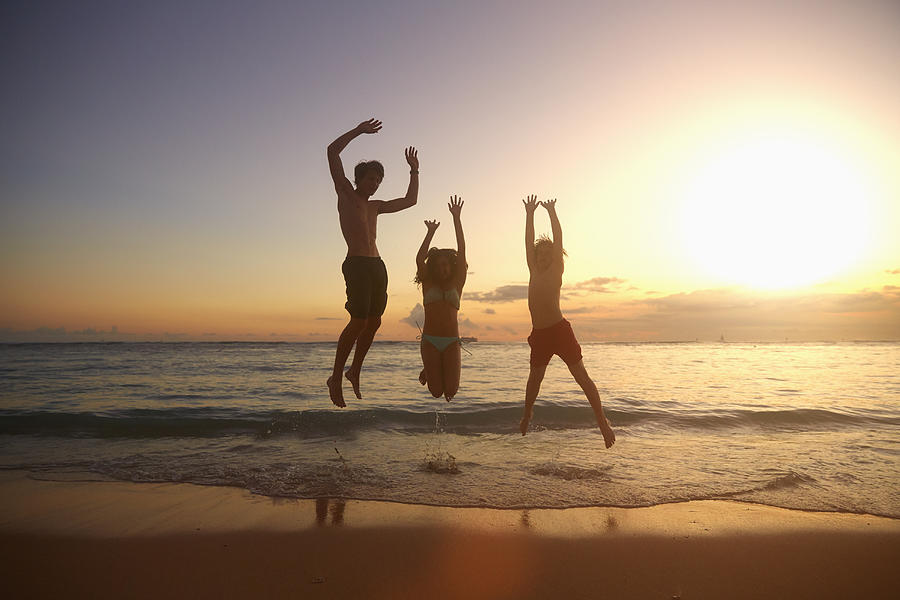 Caucasian children jumping for joy on beach Photograph by Colin Anderson Productions pty ltd