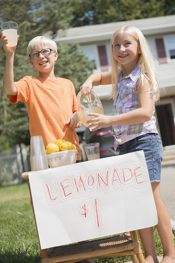 Caucasian children selling lemonade in front yard Photograph by JGI/Jamie Grill