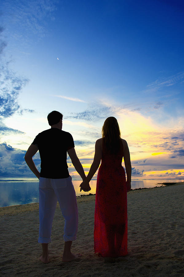 Caucasian couple holding hands on beach at sunset Photograph by Jacobs Stock Photography Ltd