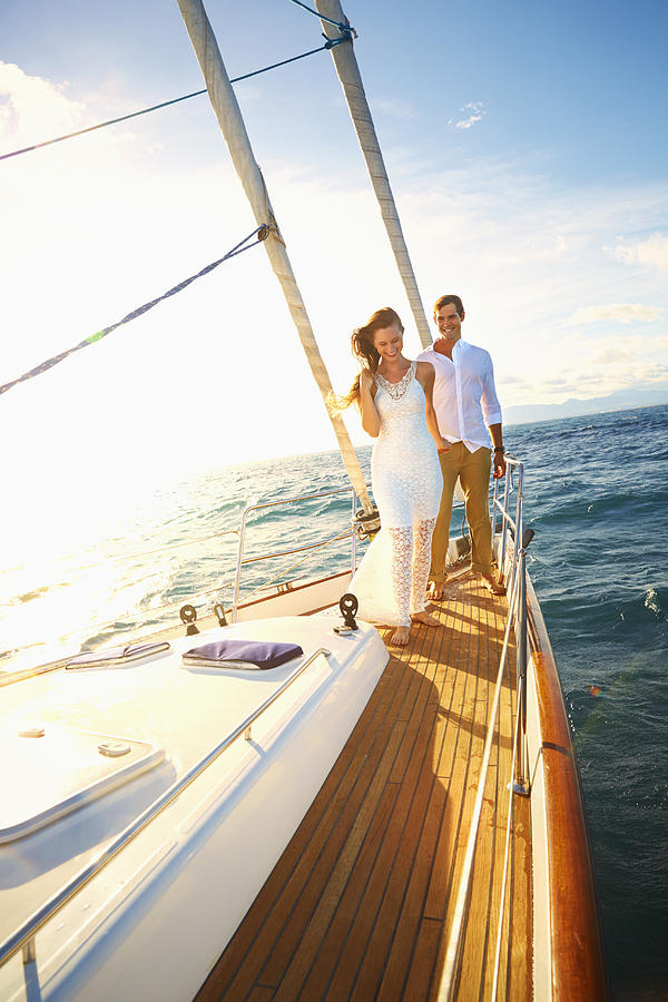 Caucasian couple standing on yacht deck Photograph by Colin Anderson Productions pty ltd
