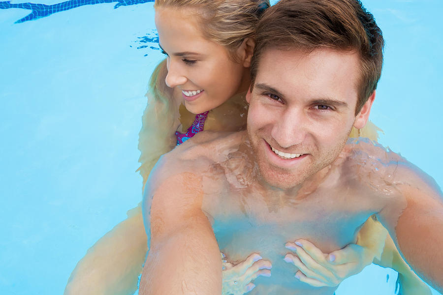 Caucasian couple together in swimming pool Photograph by Jacobs Stock Photography Ltd